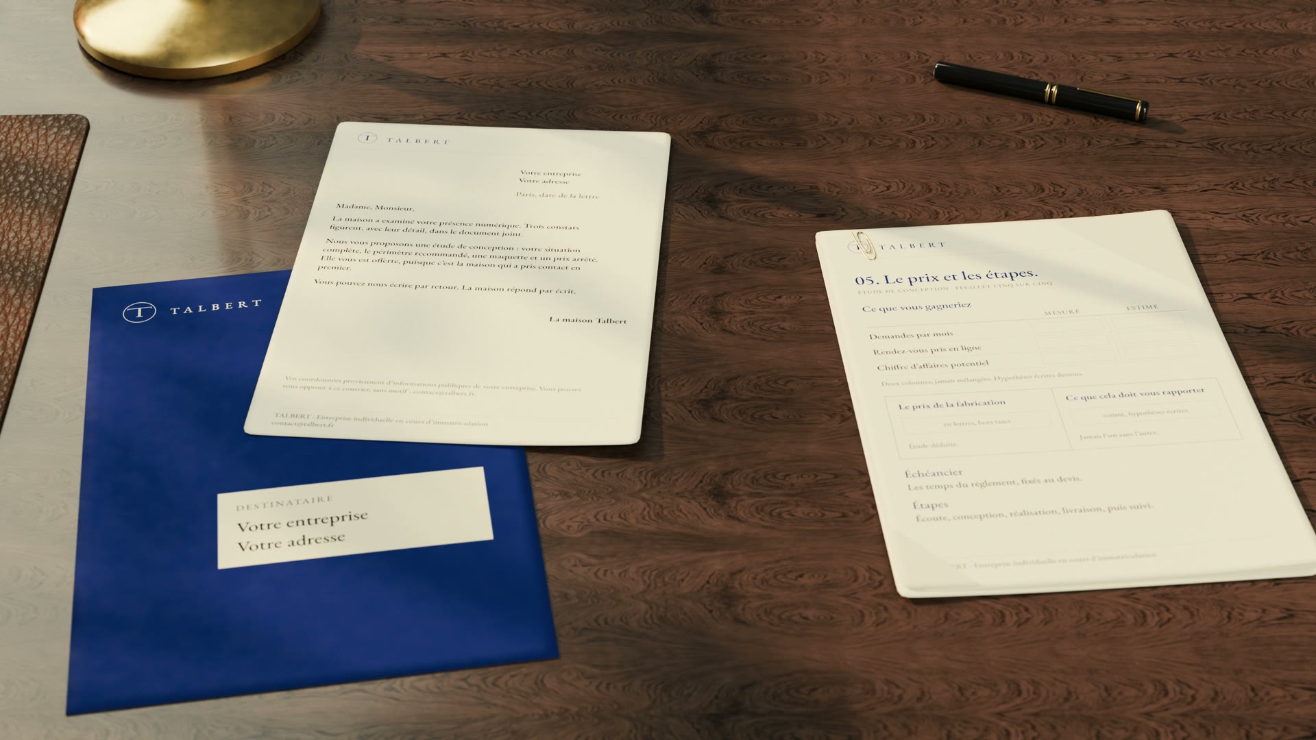 Sur un bureau en bois, l’enveloppe bleue de Talbert, une lettre et un feuillet de l’étude.